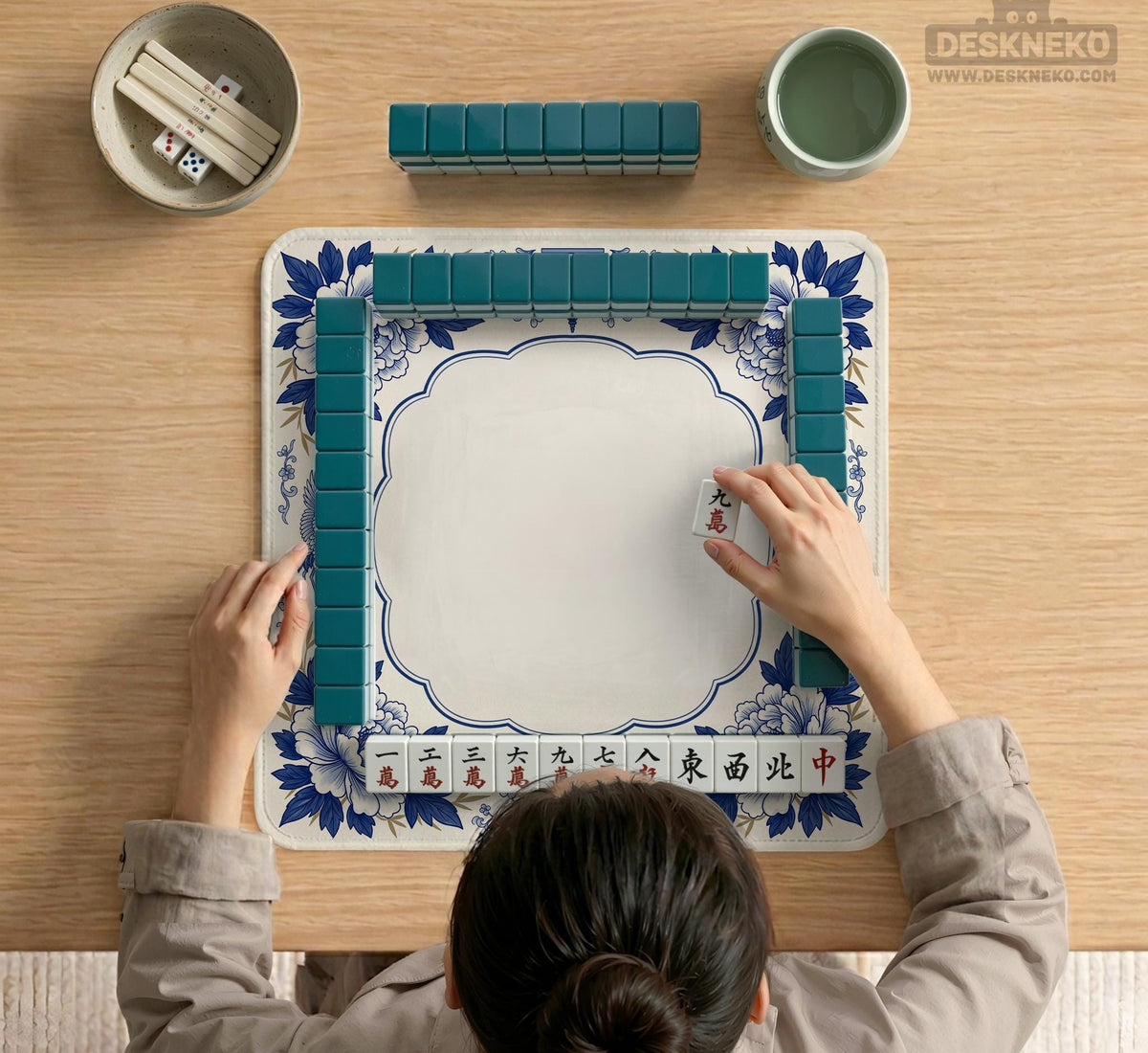 Blue and white mahjong mat with cranes, floral porcelain-style artwork, a cream center area, and a decorative border.