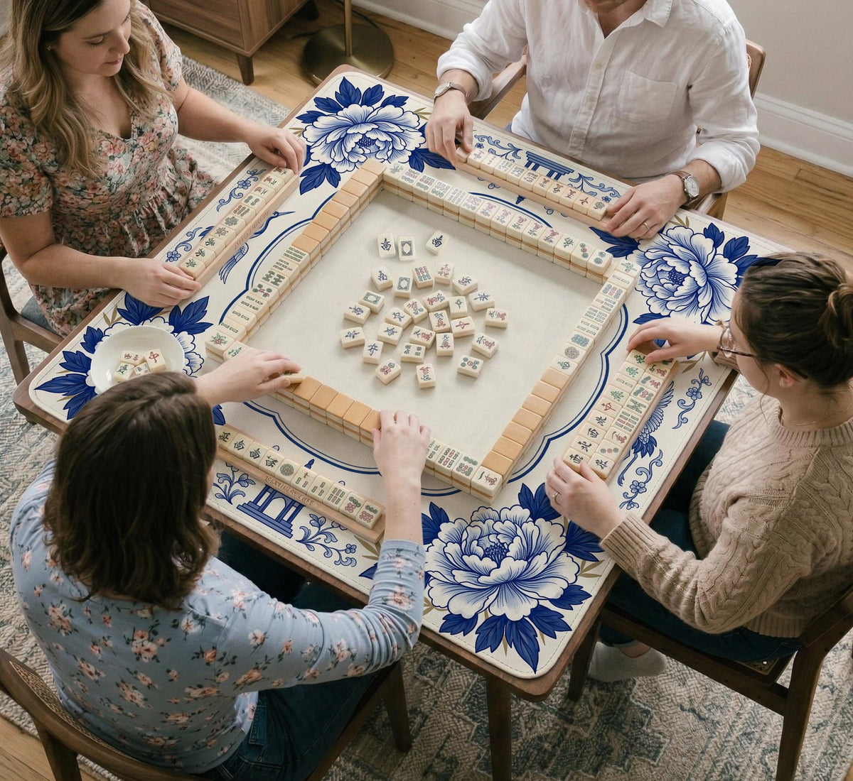 Blue and white mahjong mat with cranes, floral porcelain-style artwork, a cream center area, and a decorative border.