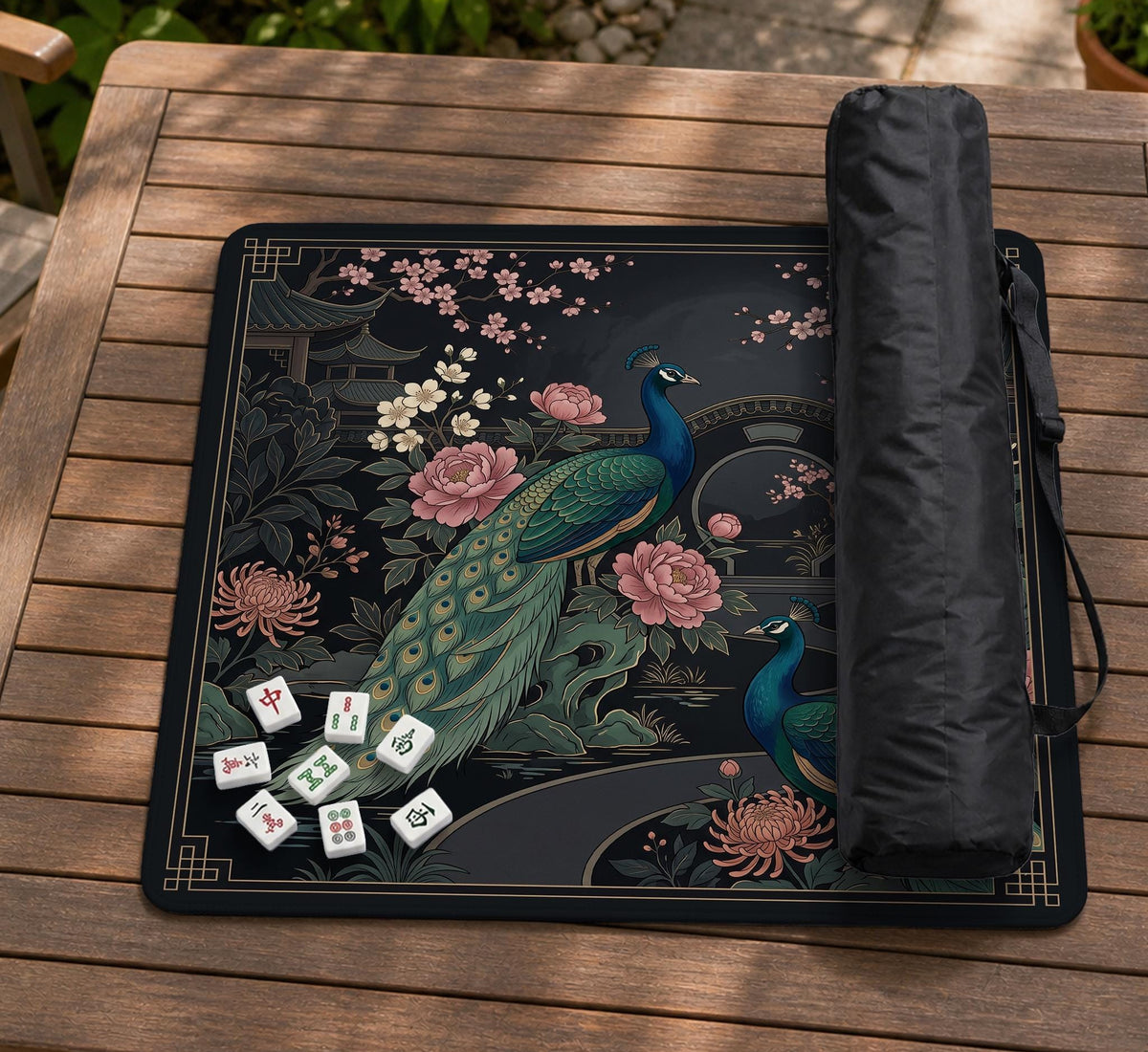 Square black mahjong mat with a gold peacock, blush flowers, and dark botanical artwork on a dark background.