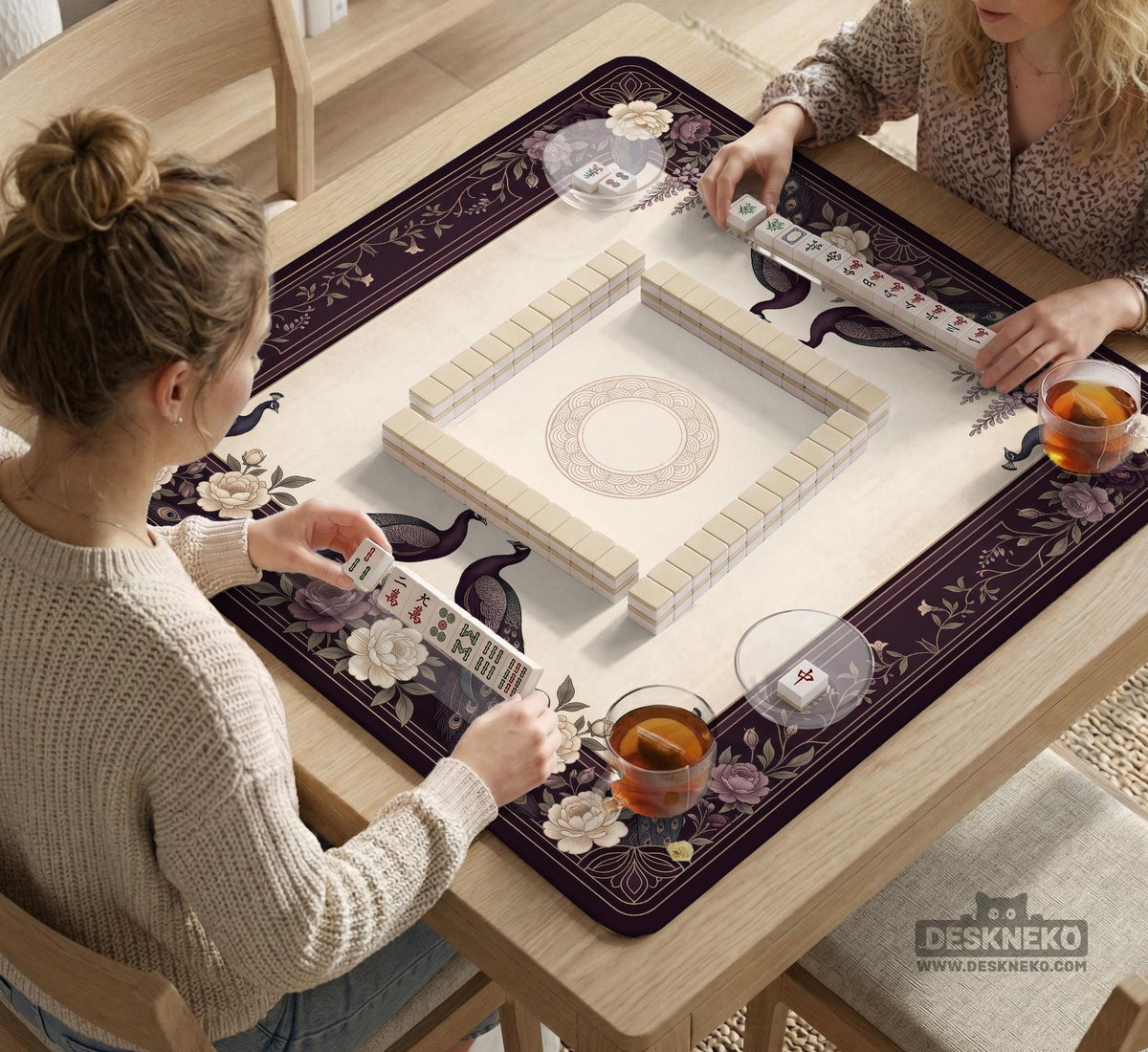 Square mahjong mat with a dark plum border, ivory floral pattern, muted sage leaves, and a decorative peacock garden design.