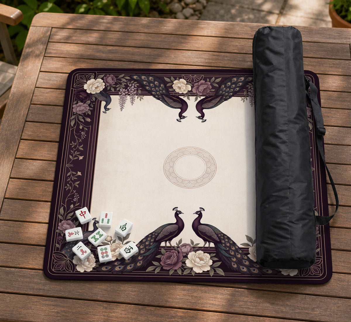 Square mahjong mat with a dark plum border, ivory floral pattern, muted sage leaves, and a decorative peacock garden design.