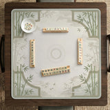Square light green mahjong mat with bamboo stalks, soft ivory details, botanical shadows, mist lines, and a circular center design.