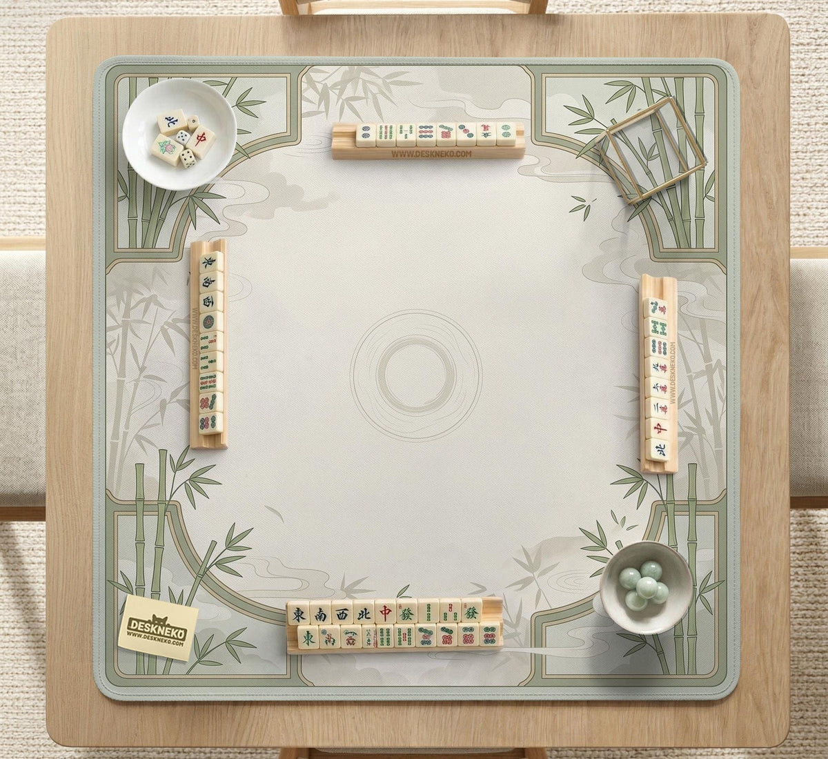 Square mahjong table mat with a pale cream center and green bamboo chinoiserie corners and border.