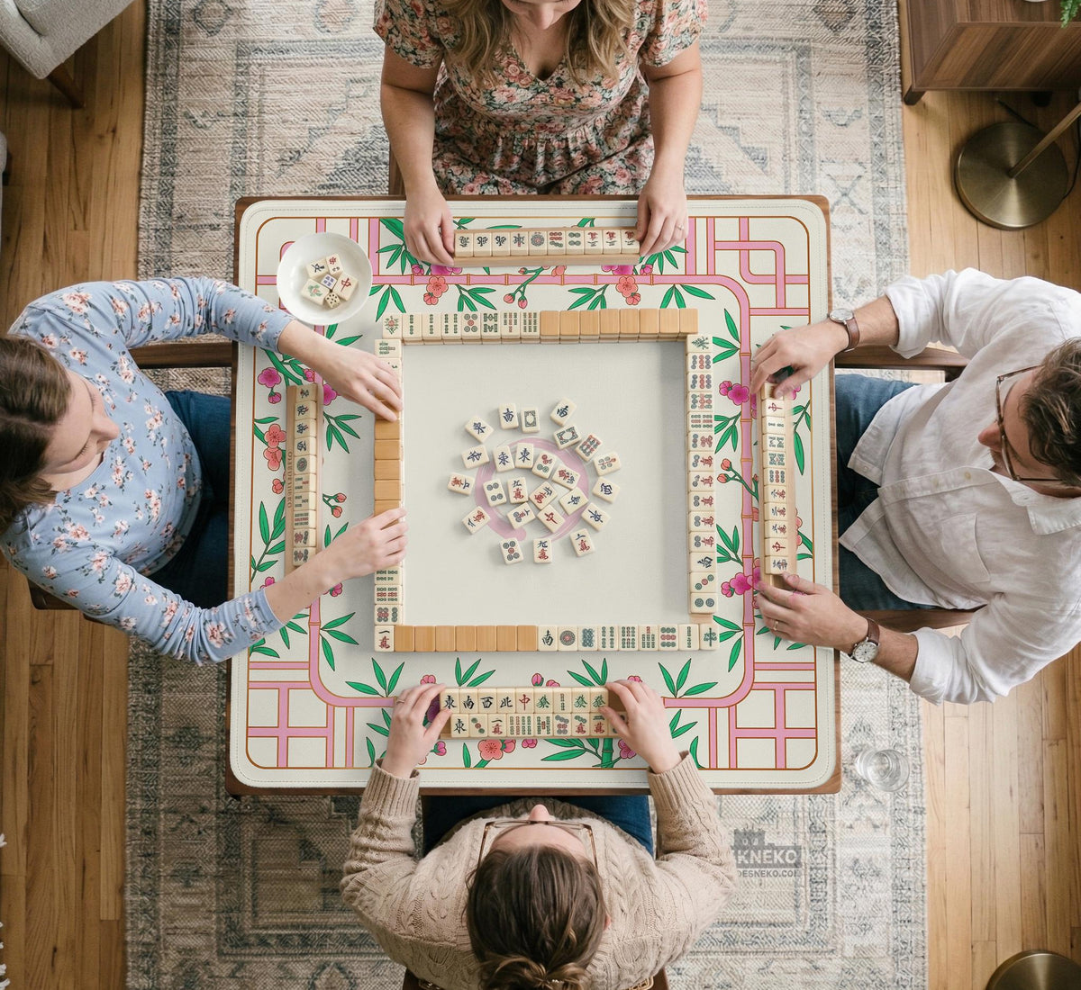 Pink cherry blossom floral mahjong table mat with a cream center and bamboo-style border design.