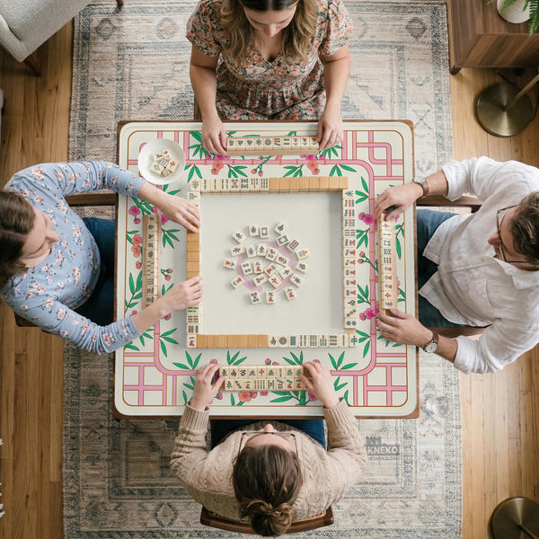 Pink cherry blossom floral mahjong table mat with a cream center and bamboo-style border design.