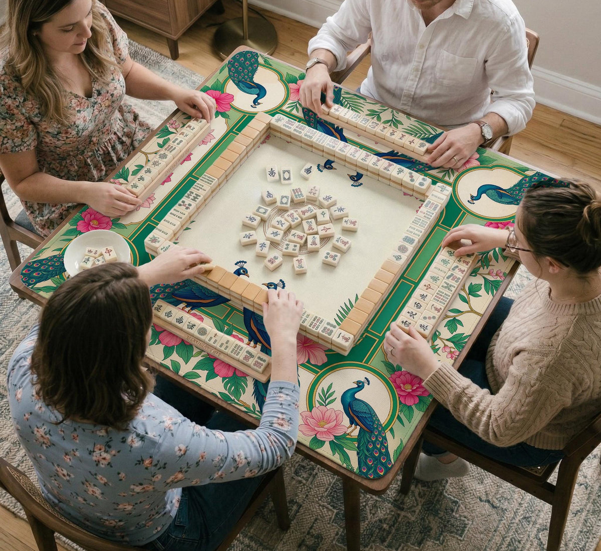 Green mahjong mat with peacocks, hibiscus flowers, tropical leaves, cream center space, and a scalloped floral border.
