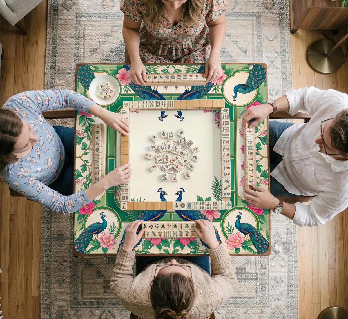 Green mahjong mat with peacocks, hibiscus flowers, tropical leaves, cream center space, and a scalloped floral border.