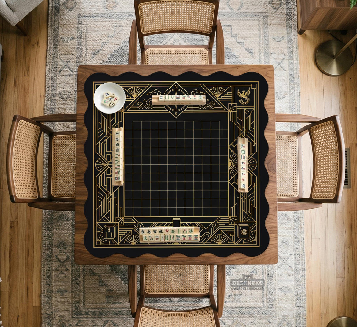 Black and gold square mahjong mat with a scalloped edge, geometric border, thin line details, fan motifs, and dragon and phoenix accents around an open center.
