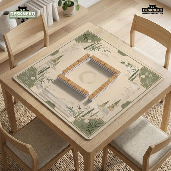 Square mahjong mat with a sage green bamboo and mountain design, cream center, scalloped border details, and gold line accents.