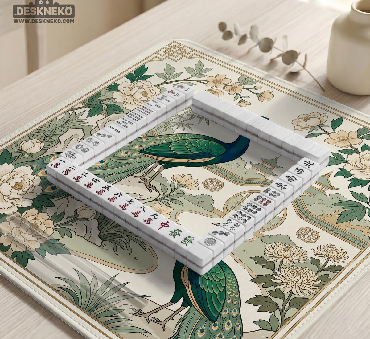 A green mahjong mat with peacock, floral, bamboo, pagoda, and gold border artwork in a scalloped chinoiserie style.