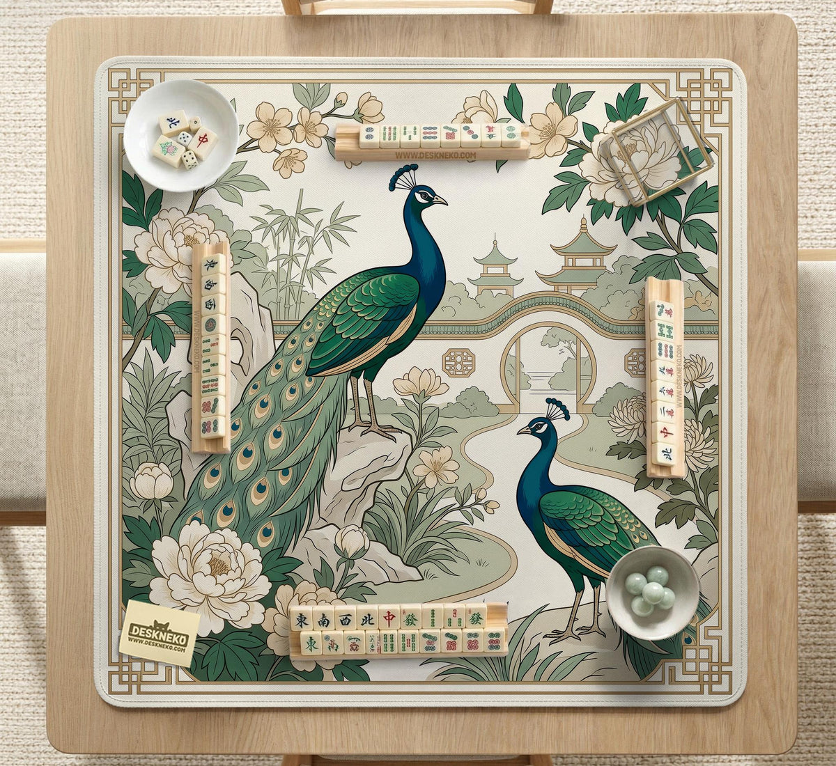 A green mahjong mat with peacock, floral, bamboo, pagoda, and gold border artwork in a scalloped chinoiserie style.