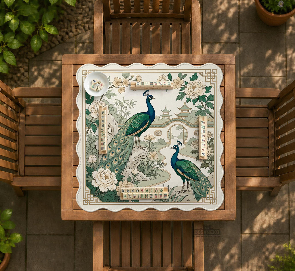 A green mahjong mat with peacock, floral, bamboo, pagoda, and gold border artwork in a scalloped chinoiserie style.
