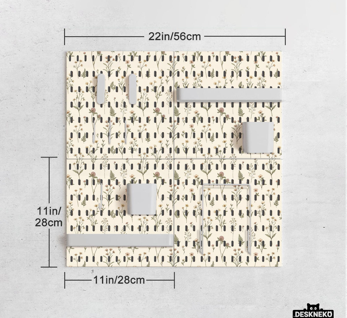 Cream pegboard wall organizer with small floral print, sage green stems, black slot layout, shelves, hooks, clips, and containers.