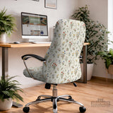Cream chair cover with a scattered cottage garden floral print in red, blue, yellow, and green on a light background.