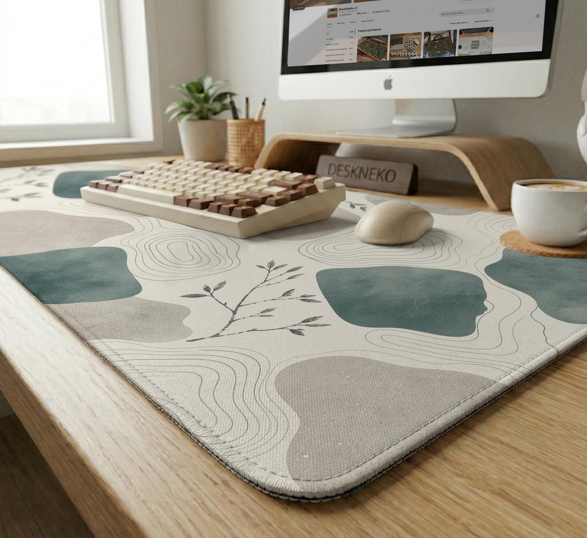 A desk mat with sage green abstract blocks, cream space, gray stone-like shapes, fine topographic contour lines, and small branch details.