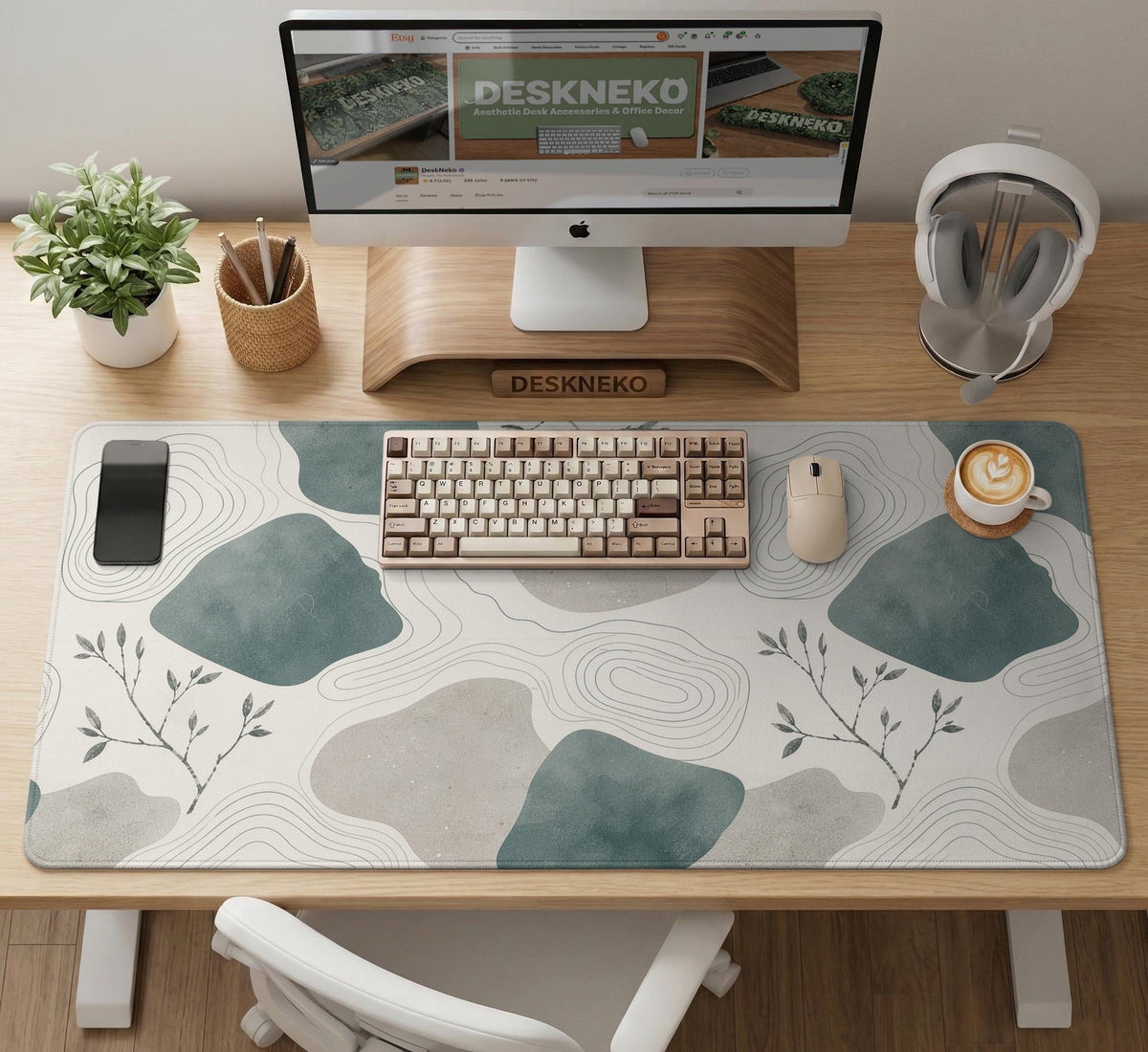 A desk mat with sage green abstract blocks, cream space, gray stone-like shapes, fine topographic contour lines, and small branch details.