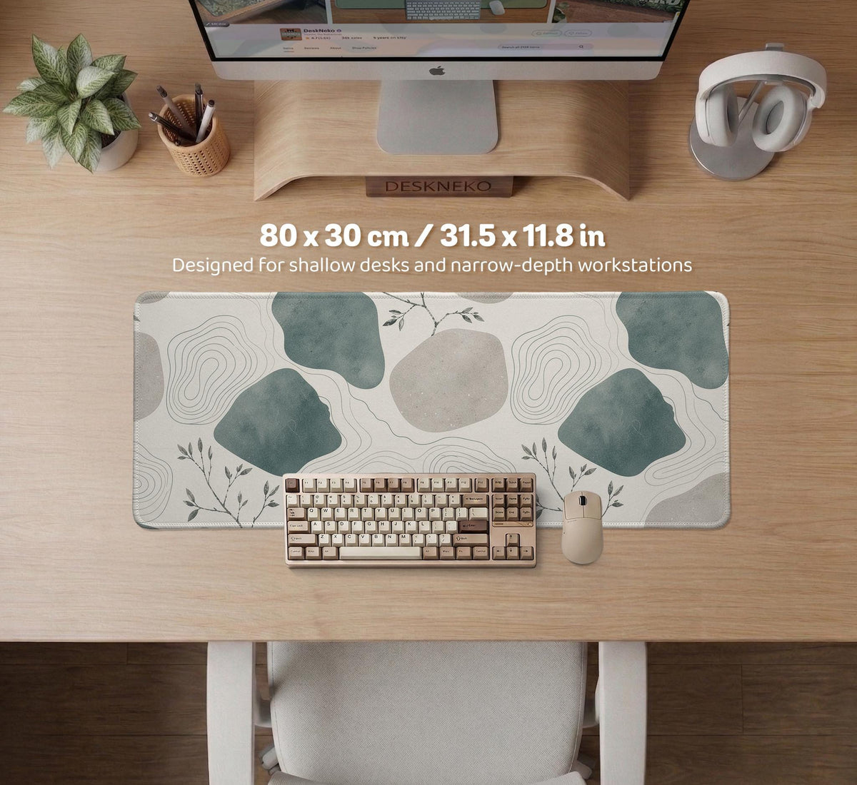 A desk mat with sage green abstract blocks, cream space, gray stone-like shapes, fine topographic contour lines, and small branch details.