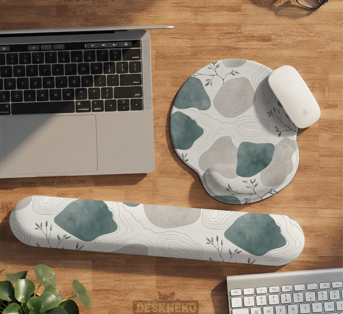 Sage green ergonomic mousepad and keyboard wrist rest with abstract shapes, soft gray details, cream space, topographic contour lines, and leafy branch accents.