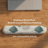 Sage green ergonomic mousepad and keyboard wrist rest with abstract shapes, soft gray details, cream space, topographic contour lines, and leafy branch accents.