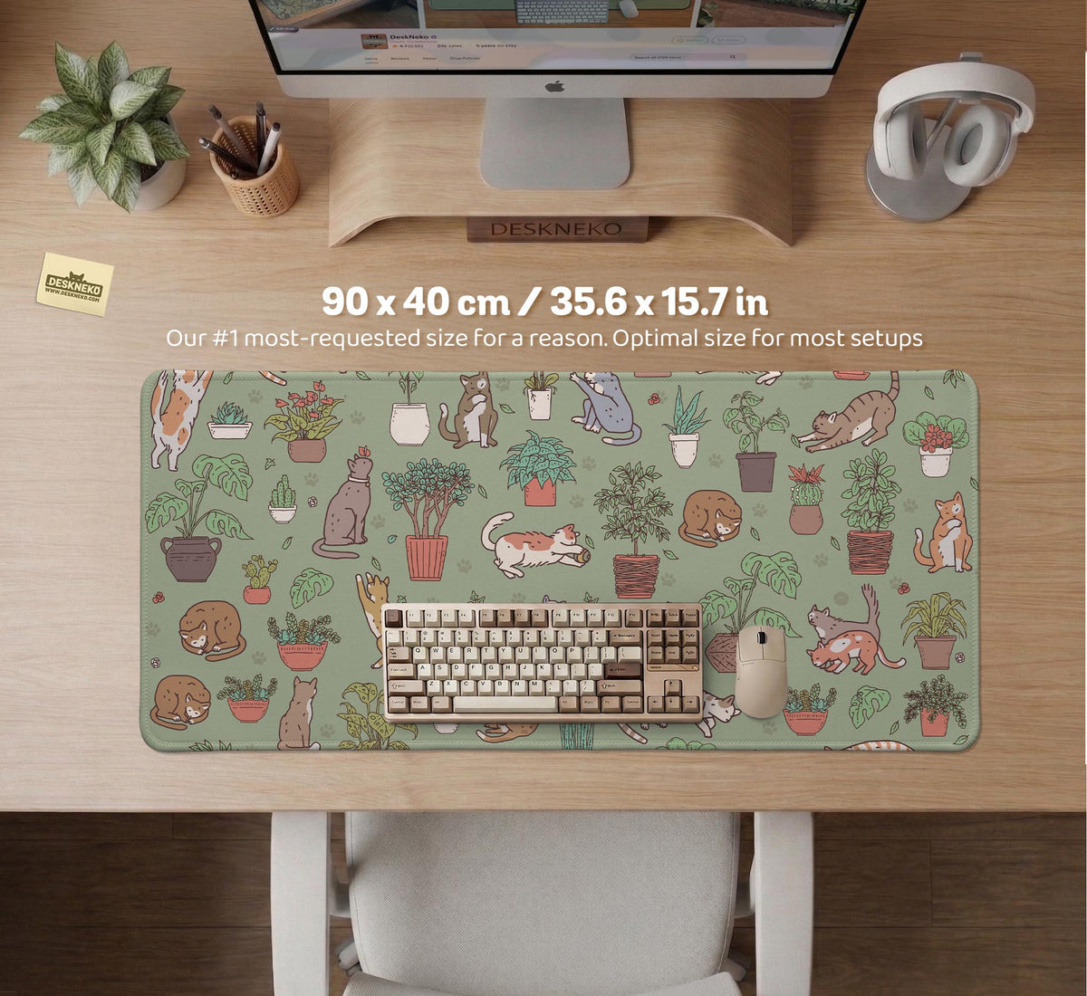 A desk mat with a repeating pattern of cats, leafy houseplants, cactus pots, and small plant-shop style details in sage green.
