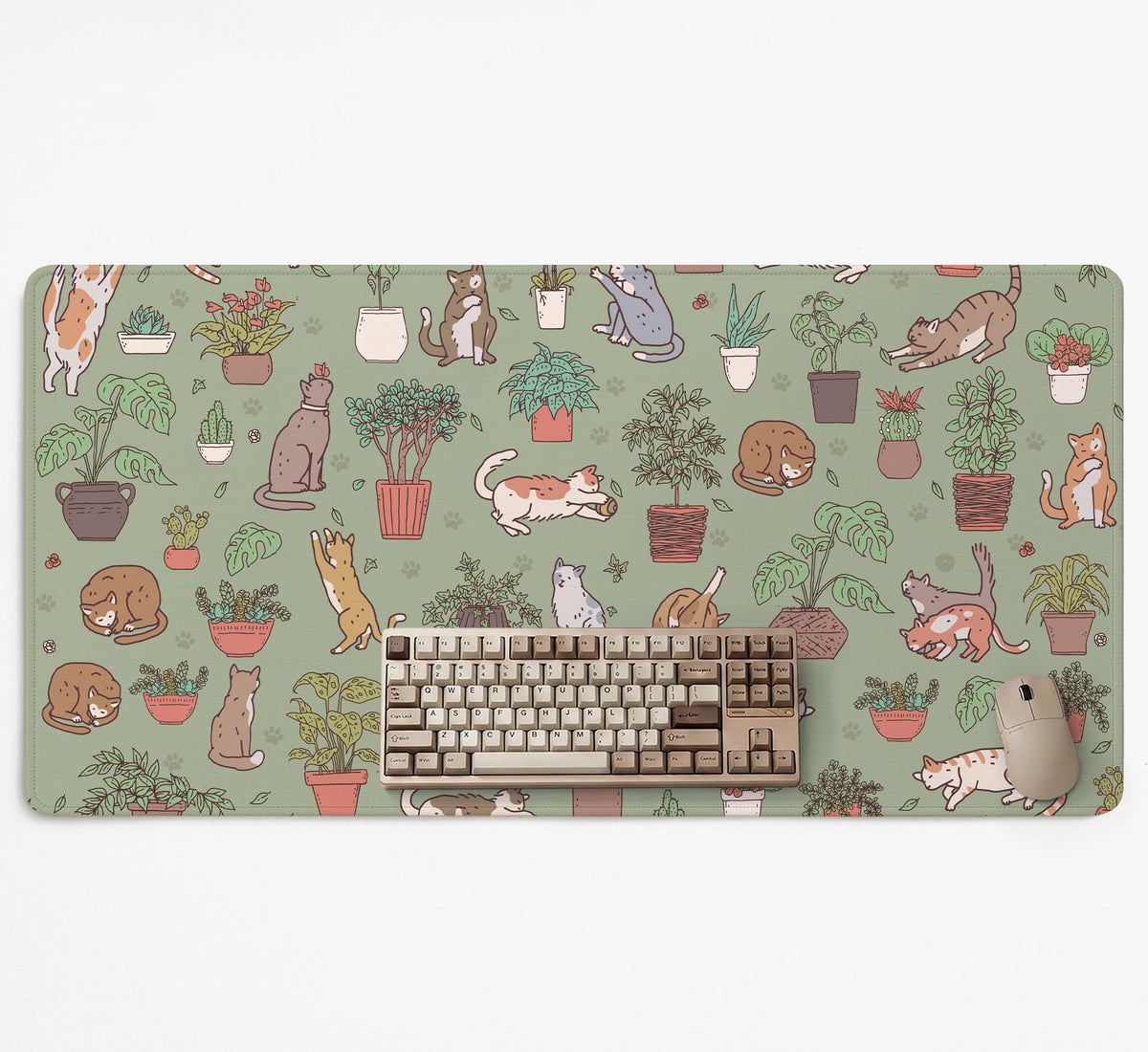 A desk mat with a repeating pattern of cats, leafy houseplants, cactus pots, and small plant-shop style details in sage green.