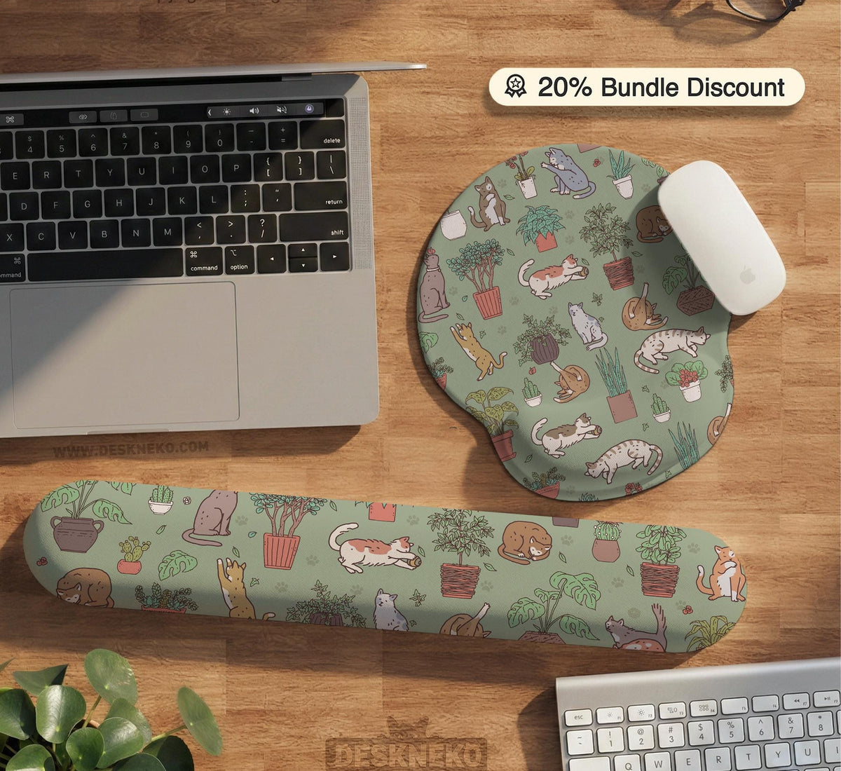 A desk mat with a repeating pattern of cats, leafy houseplants, cactus pots, and small plant-shop style details in sage green.