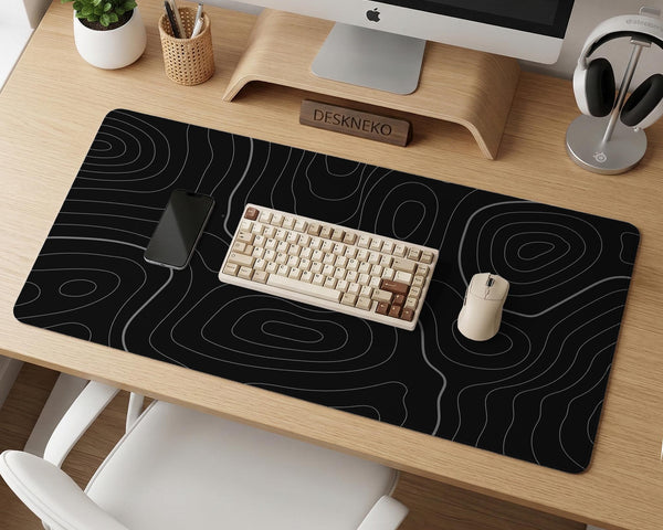 Black desk mat with a thin gray topographic contour line pattern.