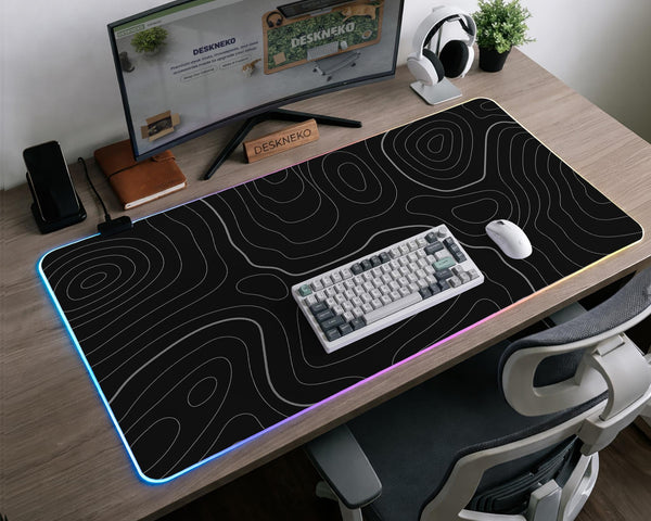 Black desk mat with a thin gray topographic contour line pattern.
