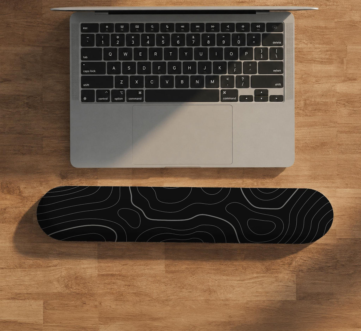 Black mousepad with a gray topographic contour line pattern shown with matching keyboard wrist rest options.