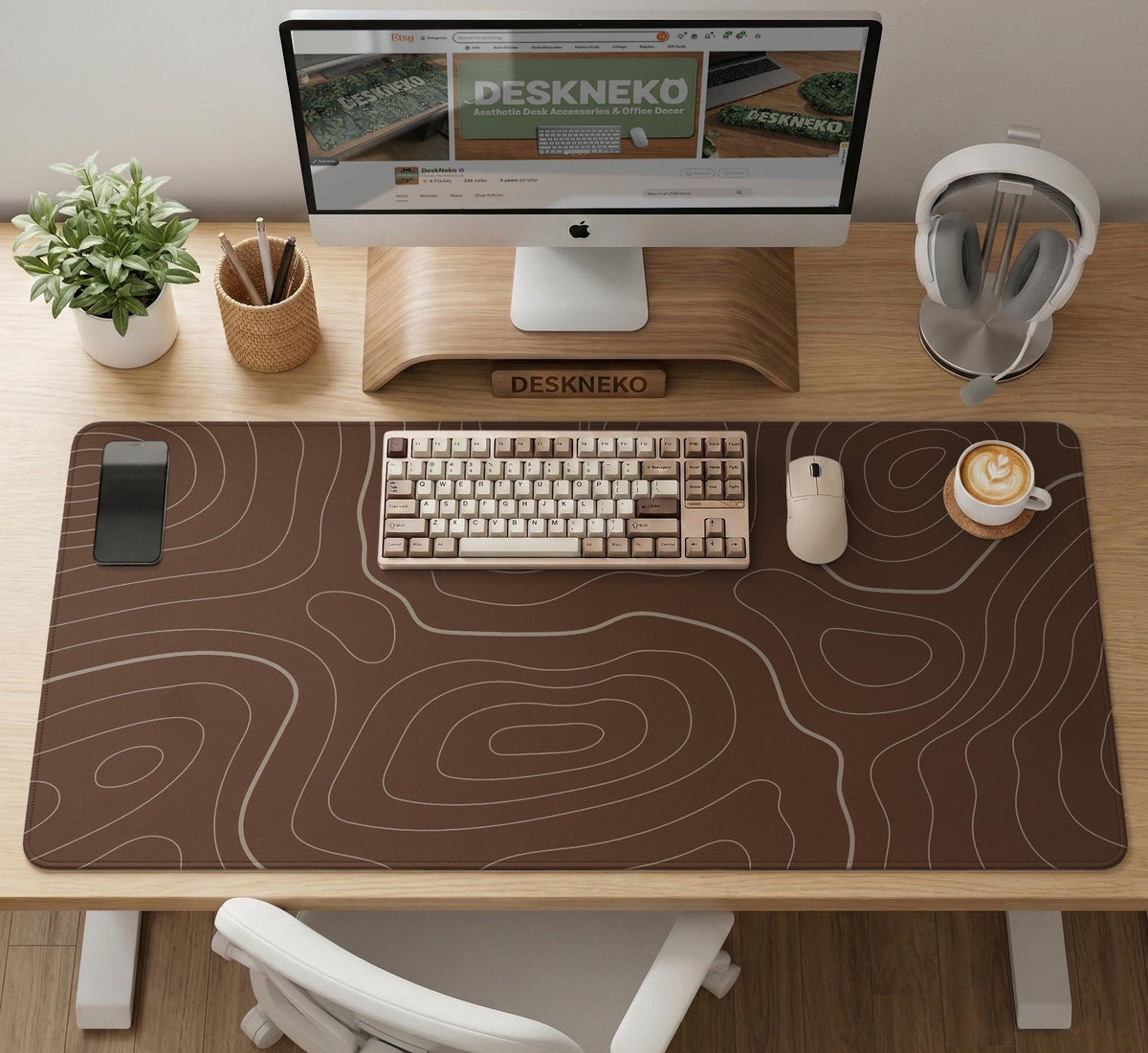 Brown desk mat with a repeating topographic contour line pattern in a neutral earth tone design.