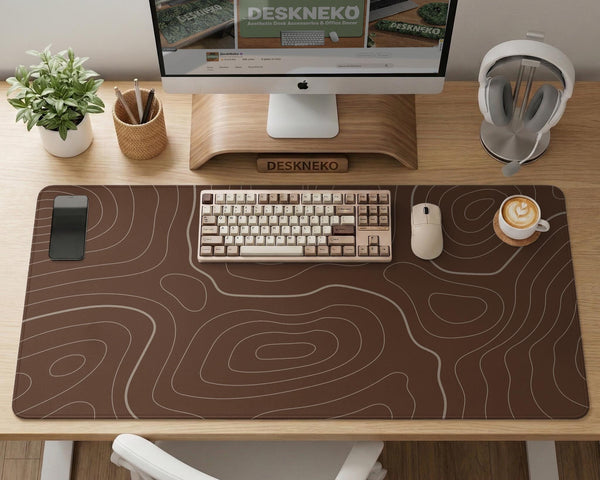 Brown desk mat with a repeating topographic contour line pattern in a neutral earth tone design.