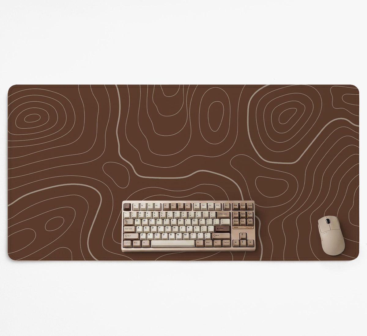 Brown desk mat with a repeating topographic contour line pattern in a neutral earth tone design.