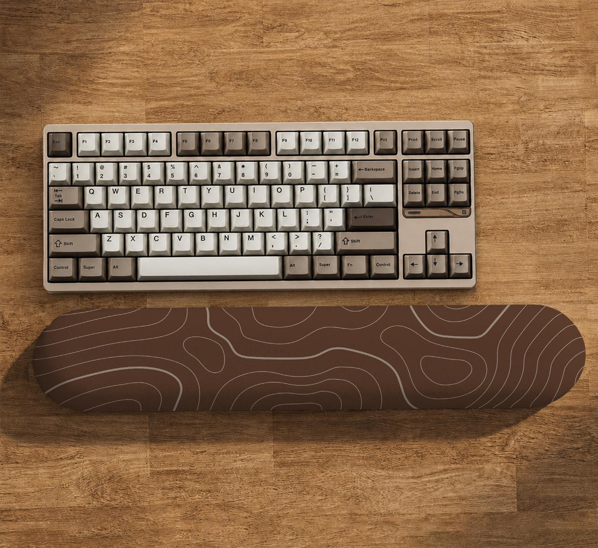 Brown mousepad and keyboard wrist rest with a topographic contour-line pattern.
