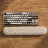 Beige mousepad and keyboard wrist rest with a topographic line pattern shown in a neutral desk setup.