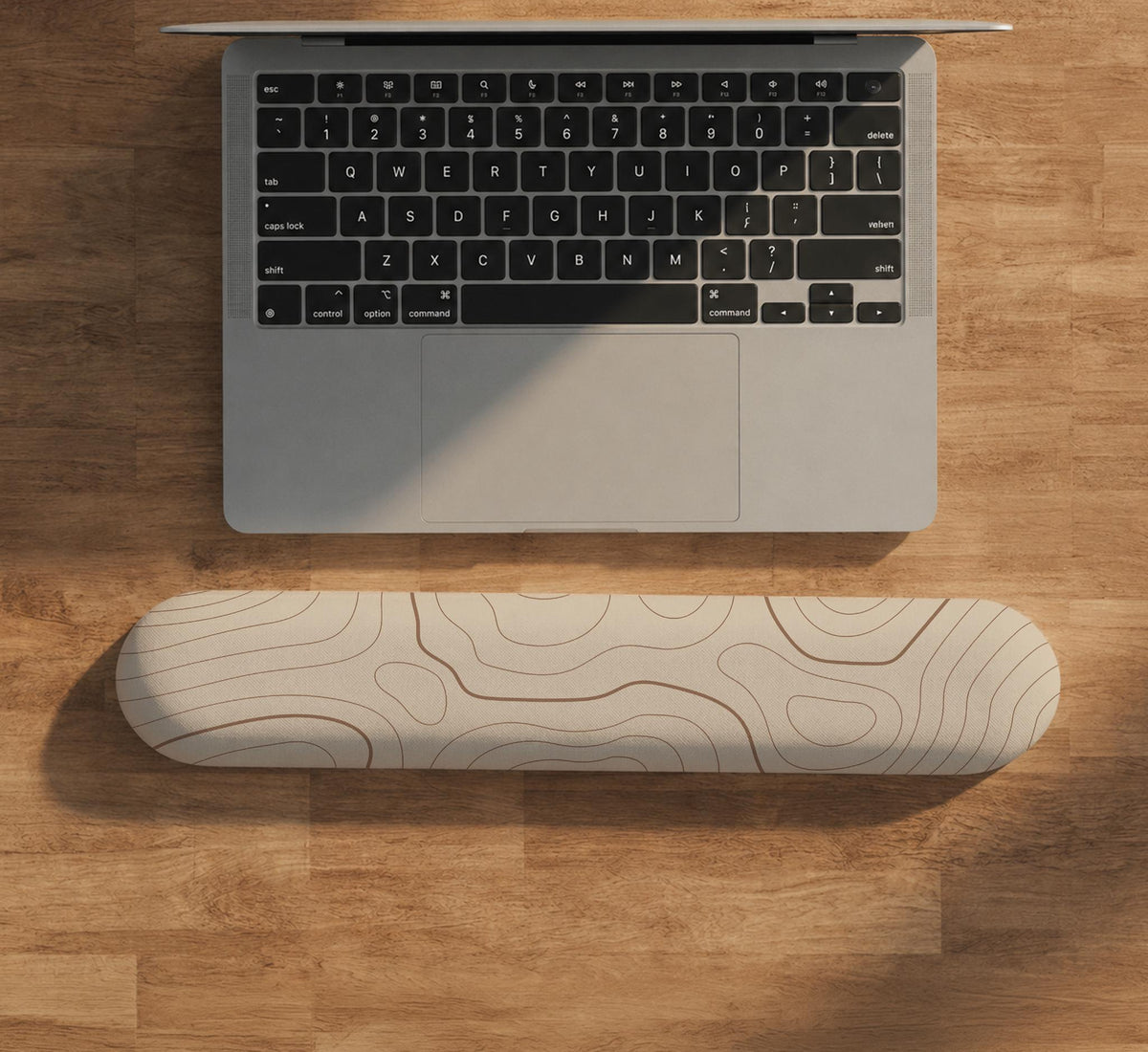 Beige mousepad and keyboard wrist rest with a topographic line pattern shown in a neutral desk setup.