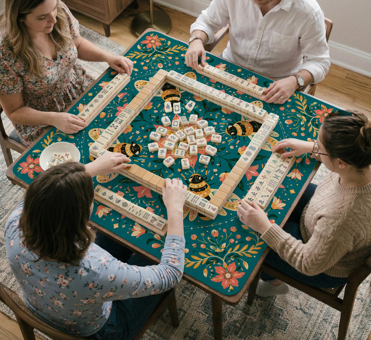 Green mahjong mat with a botanical bee and floral mandala design in teal, coral, cream, and gold.