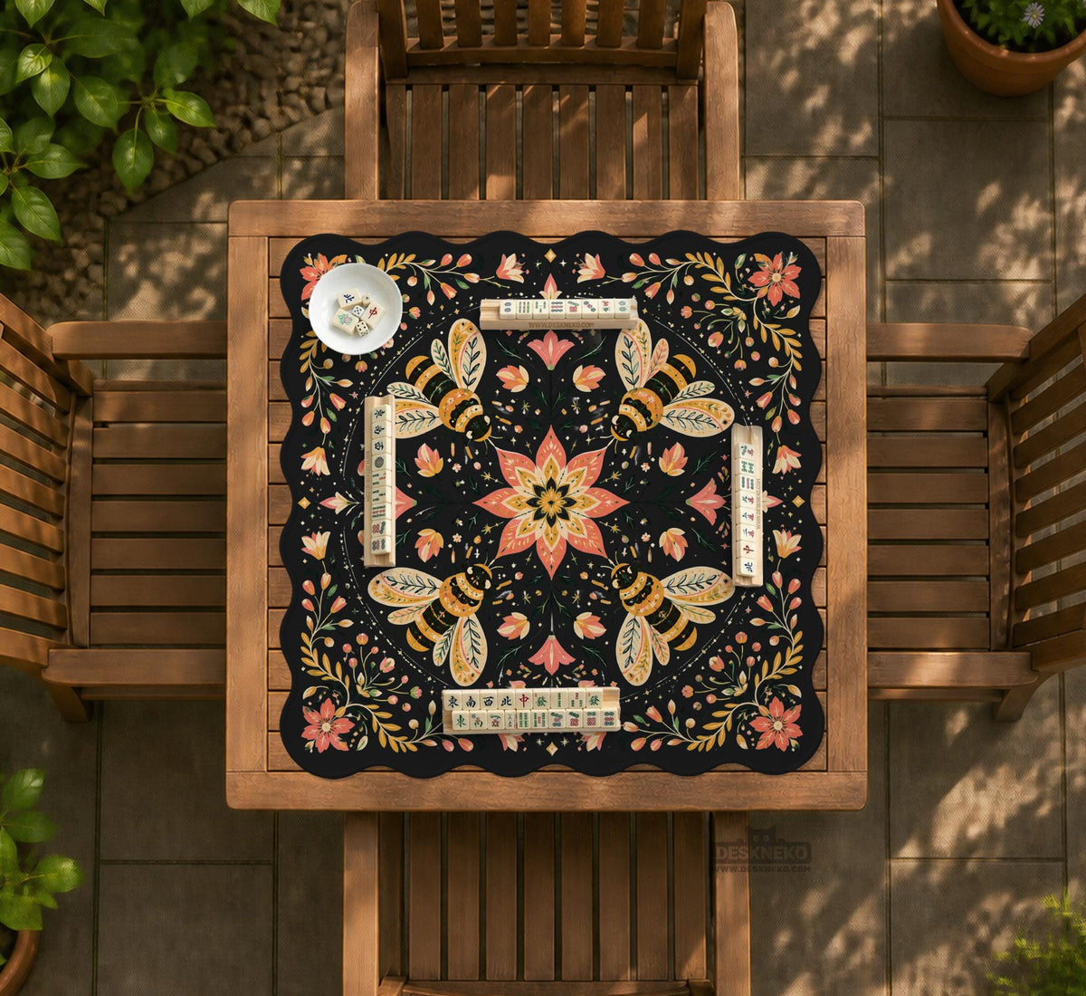 Black mahjong mat with a symmetrical botanical design, coral flowers, golden leaves, and small bees.
