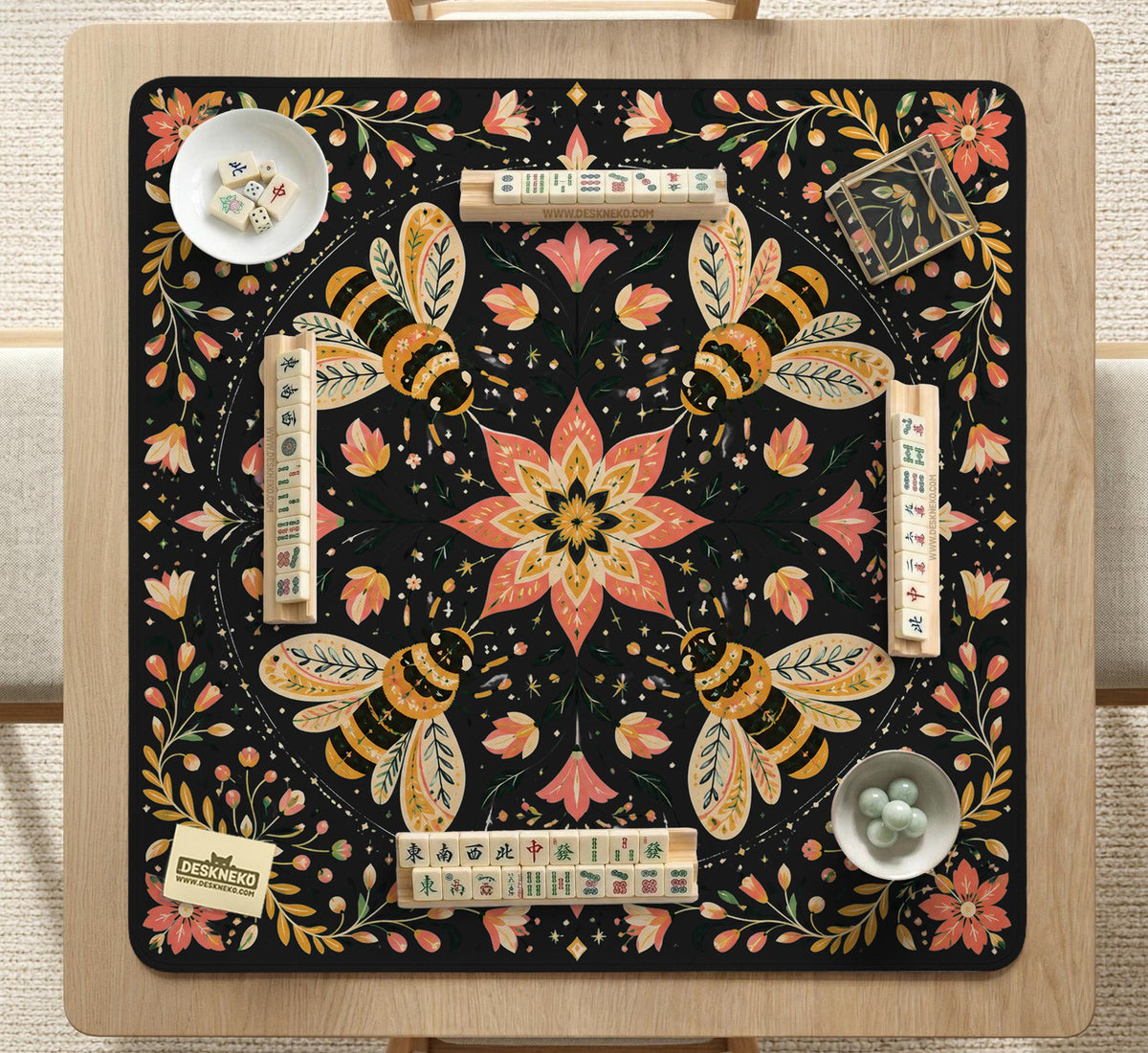 Black mahjong mat with a symmetrical botanical design, coral flowers, golden leaves, and small bees.
