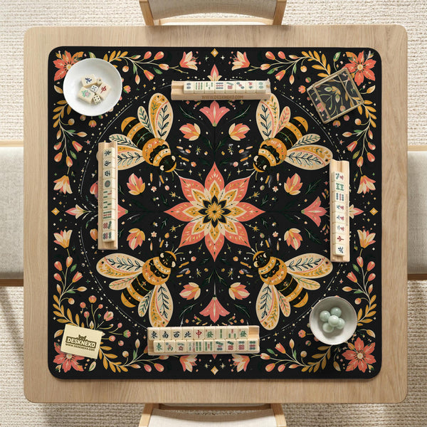 Black mahjong mat with a symmetrical botanical design, coral flowers, golden leaves, and small bees.