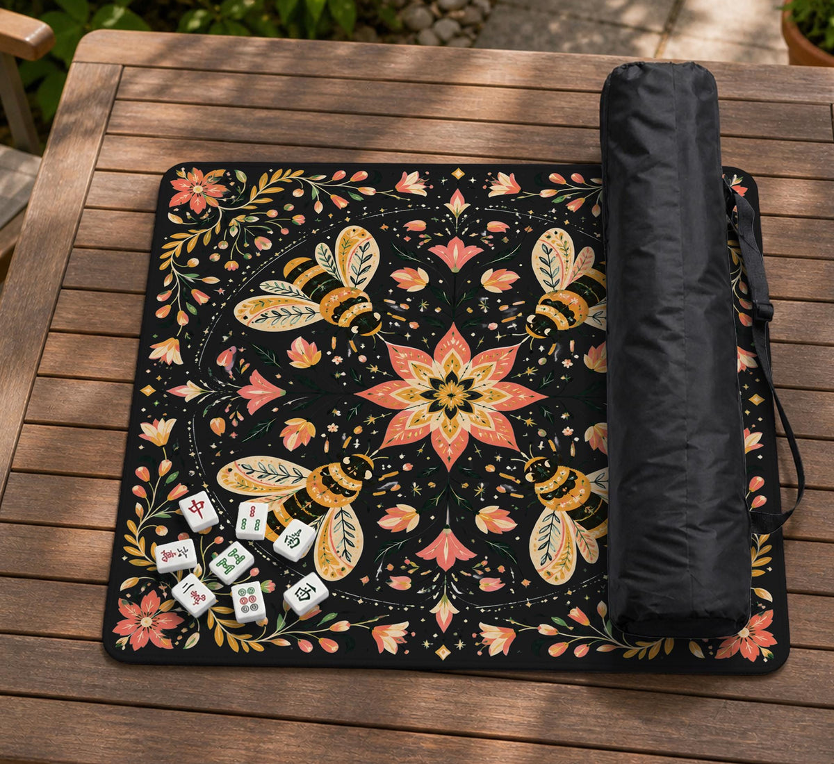 Black mahjong mat with a symmetrical botanical design, coral flowers, golden leaves, and small bees.