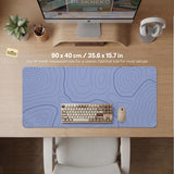 A periwinkle deskmat with thin blue contour lines printed across the surface.