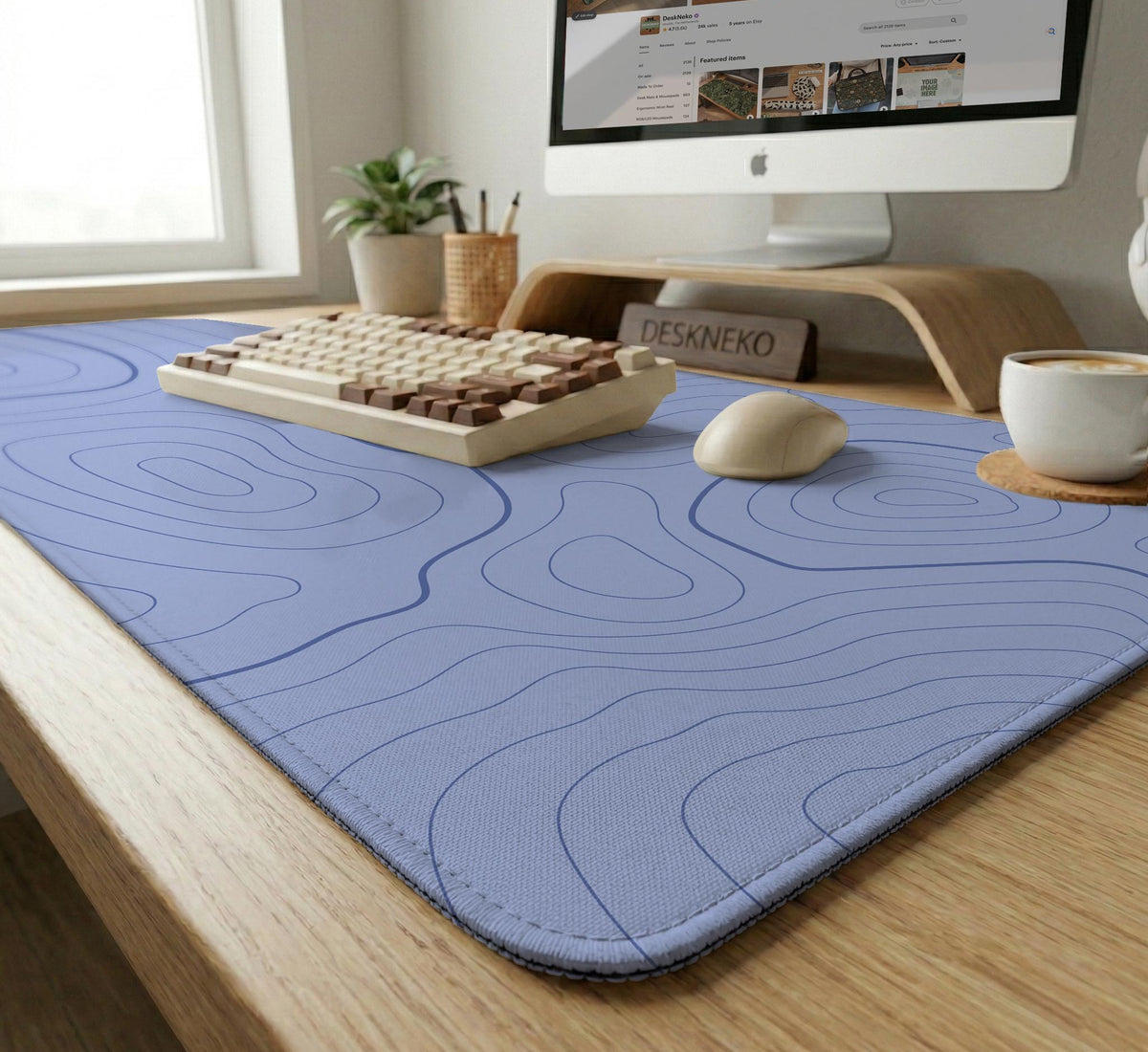 A periwinkle deskmat with thin blue contour lines printed across the surface.
