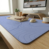 A periwinkle deskmat with thin blue contour lines printed across the surface.