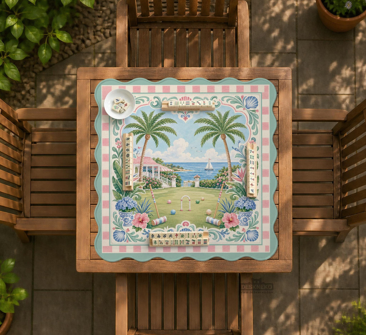 Pastel mahjong mat with a pink gingham border, seashells, hydrangea pots, palm trees, croquet details, and a coastal garden scene.