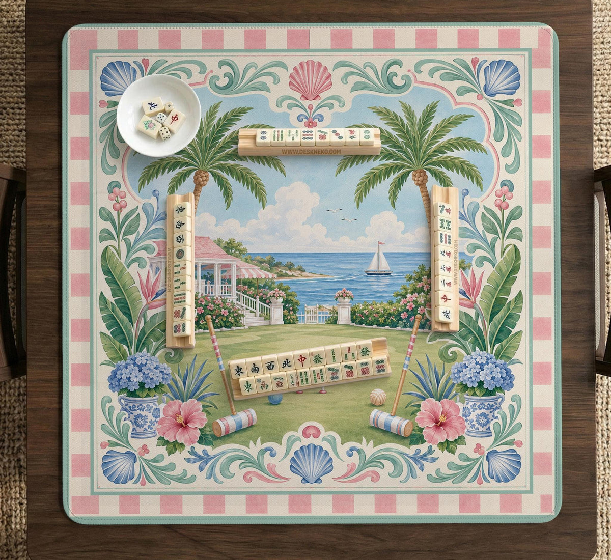 Pastel mahjong mat with a pink gingham border, seashells, hydrangea pots, palm trees, croquet details, and a coastal garden scene.