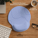 A periwinkle deskmat with thin blue contour lines printed across the surface.