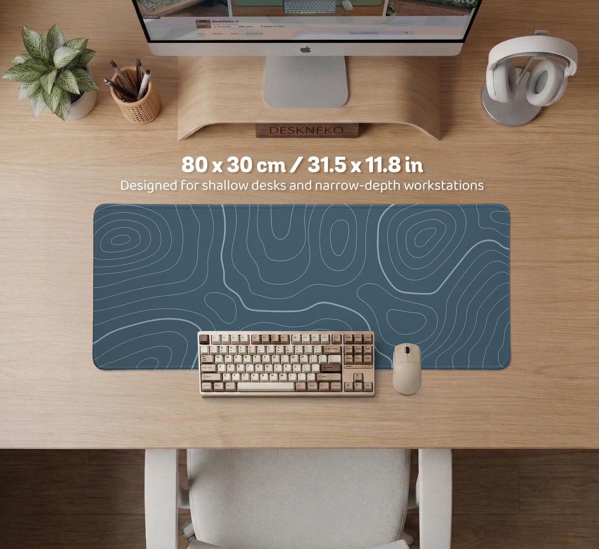 A slate blue desk mat with thin contour line map art on a light background.