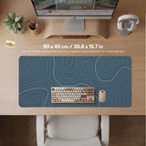Blue mousepad with a topographic line pattern on a slate background.