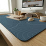 A slate blue desk mat with thin contour line map art on a light background.