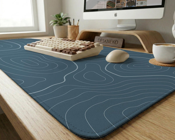 Blue mousepad with a topographic line pattern on a slate background.